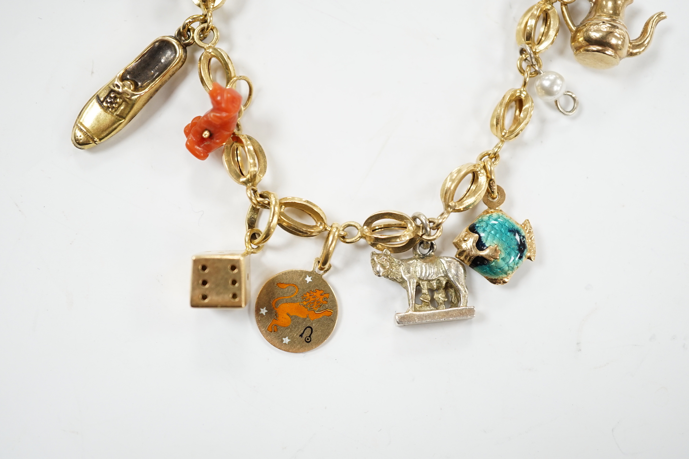 An Italian 750 charm bracelet, hung with eleven assorted charms including 9ct, yellow metal and 800 standard white metal